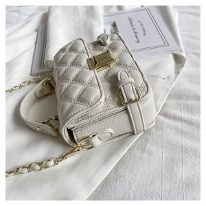 White quilted crossbody bag detail, elegant gold chain strap and chic clasp closure.