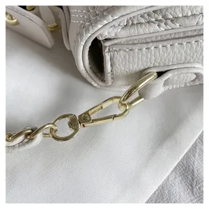 Detailed close-up of a white quilted leather chain shoulder bag with gold hardware.