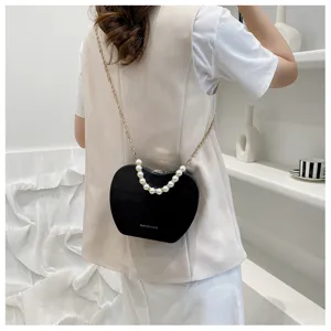 Detailed view of the stylish black apple-shaped crossbody bag with pearl handle and chain.