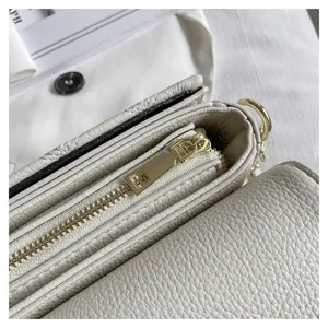 Detailed shot of white leather crossbody bag zipper and texture, high quality accent
