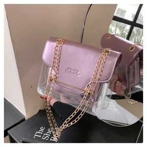Clear crossbody bag with metallic pink flap and gold chain strap. Detailed view of shiny purse.
