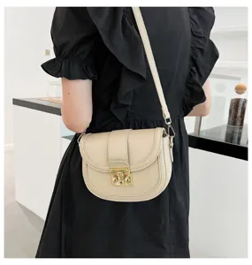 Women stylish beige saddle bag worn across shoulder, showing detailed design and elegance.