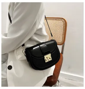 Elegant black saddle bag for women, stylish minimalist shoulder and crossbody bag with gold lock.