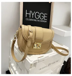 Beige PU leather women saddle bag featuring metal lock closure and stylish shoulder strap.