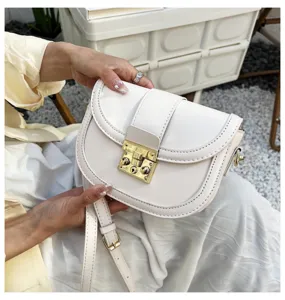 White PU leather saddle bag detail, stylish minimalist shoulder bag with gold hardware lock.