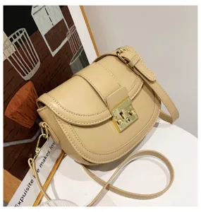 Minimalist beige women saddle bag detail view, elegant leather crossbody bag with metal lock.