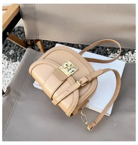 Chic women's saddle bag in camel leather with metal lock detail and adjustable strap.