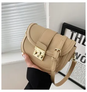 Classic khaki leather saddle crossbody bag featuring elegant gold metal lock and strap design.