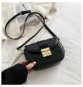 Black leather saddle bag featuring a chic gold tone metal lock and adjustable shoulder strap.