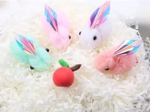 Detailansicht süßer, flauschiger Hasen-Haarspangen mit schimmernden Flügeln auf weißem Papier.