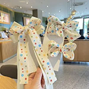 Detailed view of cute children hair clips with colorful polka dot bows, sweet style for daily wear.