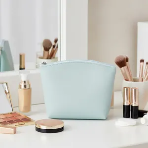 Detalle de bolsa cosmética de piel sintética azul claro con cremallera elegante y fina.