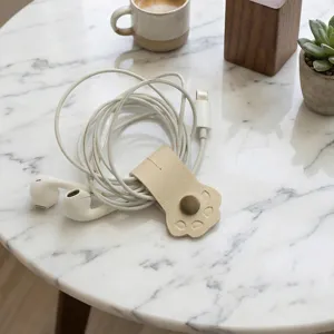 Detail van de schattige lederen poot kabelorganizer, compacte drukknoopriem voor het bureau.