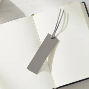 Detailansicht eines minimalistischen grauen PU Leder Lesezeichens auf offenem Notizbuch.