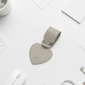 Etiqueta de equipaje de cuero en forma de corazón gris claro, accesorio elegante.