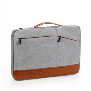 Housse pour ordinateur portable 13 pouces grise avec poignée en cuir marron et poches zippées.