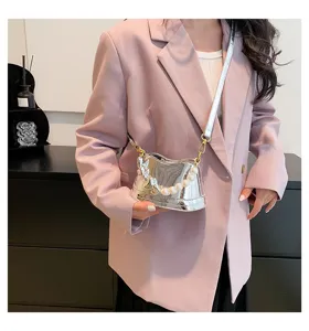 Metallicfarbene Eimer-Handtasche mit Perlenhenkel und Schultergurt getragen mit Blazer.