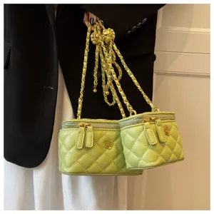 Quilted chain vanity bag in light green, featuring metallic flower charm and shoulder strap.