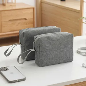 Bolso cosmetico de viaje de tela gris portatil con mango y cremallera para uso diario.