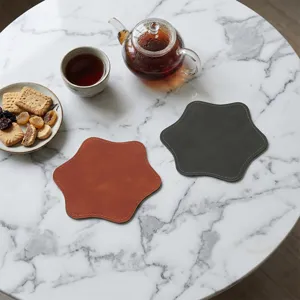 Gedetailleerd overzicht van stijlvolle zeshoekige PU leren onderzetters op marmeren tafel.