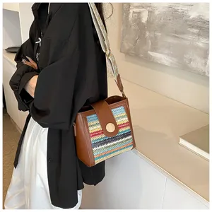 Detailed view of the stylish woven bucket bag featuring colorful patterns and a wide strap.