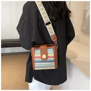 Detailed shot of trendy woven bucket bag with wide strap showcasing stylish women design.