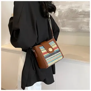 Detailed view of women's woven bucket shoulder bag with wide strap and brown leather trim.