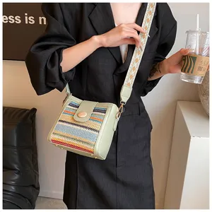 Detail view of the stylish woven crossbody bag with colorful patterns and wide strap.
