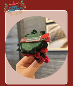 Detail view of cute children's Christmas tree hair clip, green velvet with red bow.