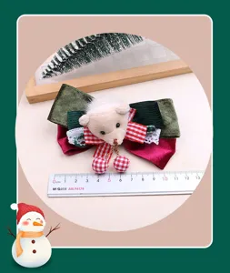 Detailansicht der Weihnachtsschleife Haarklammer mit süßem Plüschbär und festlichen Bändern.
