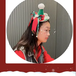 Detail view of the festive Christmas mini hat headband with plush pom-pom and bow decorations.
