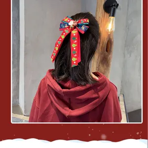 Gros plan détaillé du nœud de cheveux de Noël festif avec ruban rouge et jolis motifs d'arbres.