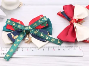 Détail d'accessoire de cheveux nœud de Noël avec ruban multicouche et pendentif flocon.