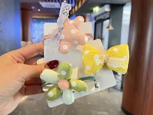 Vue détaillée d'accessoires de cheveux en tissu à pois mignons avec étoiles, nœuds et fleurs.