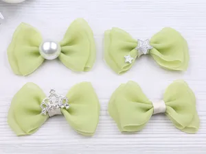 Vue détaillée de l'ensemble de nœuds pour cheveux en mousseline verte avec perles et couronnes.