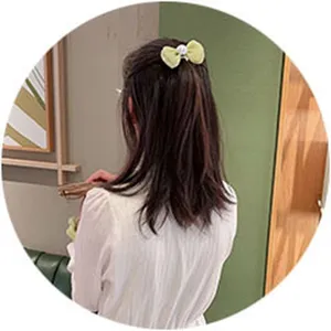 Vue détaillée d'une jolie pince à cheveux nœud en tulle vert clair avec perle.