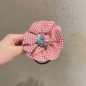 Detalle de coletero de tela con flor, bonito accesorio de estilo japonés a cuadros rojos.
