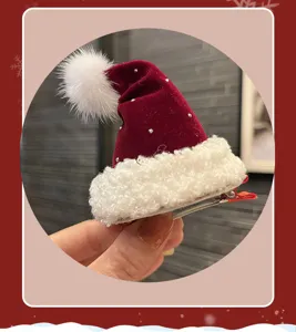 Detail of the mini red velvet Santa hat hair clip with white plush trim and rhinestones.