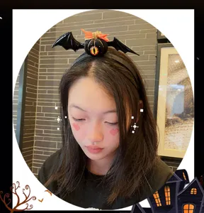 Dettaglio cerchietto pipistrello di Halloween, accessorio per capelli con occhio di zucca spaventoso.