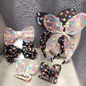 Nahaufnahme von bunten Pünktchen-Netz-Haaraccessoires, Schleifen und Haargummis.