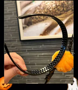 Dettaglio cerchietto Halloween con zucca di peluche e ali, divertente accessorio per feste.