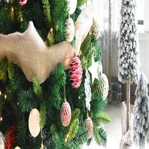 Festliche Weihnachtsbaum Dekorationsdetails mit roten Ornamenten und kleinen Bäumen.