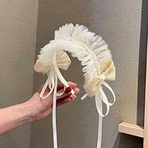 Weißes Spitzen-Haarband mit süßen Schleifen und langen Bändern für ein niedliches Styling.