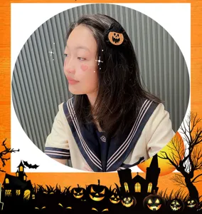 Halloween Haarklammer Detail mit niedlichem Kürbisdesign und glitzernder Oberfläche am Modell.