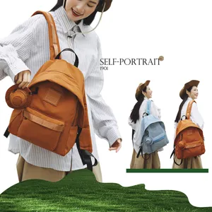 Detailansicht des stilvollen Canvas-Reiserucksacks mit Fronttasche und niedlichem Anhänger.