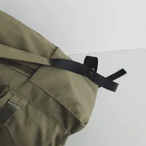 Nahaufnahme der lässigen khakigrünen Rucksack-Schultergurt- und Reißverschlussdetails.