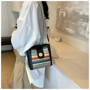 Detailed view of women's woven bucket shoulder bag with chic multicolor pattern and wide strap.