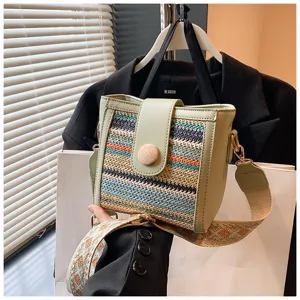 Woven bucket bag for women, stylish green PU leather trim, comfortable broad crossbody strap.