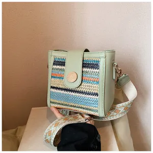 Detailed view of the woven front panel, green PU trim, and wide strap on the stylish bucket bag.