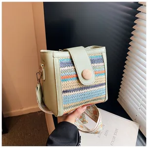 Close-up detail shot of the colorful woven crossbody bag featuring green PU leather and wooden button.